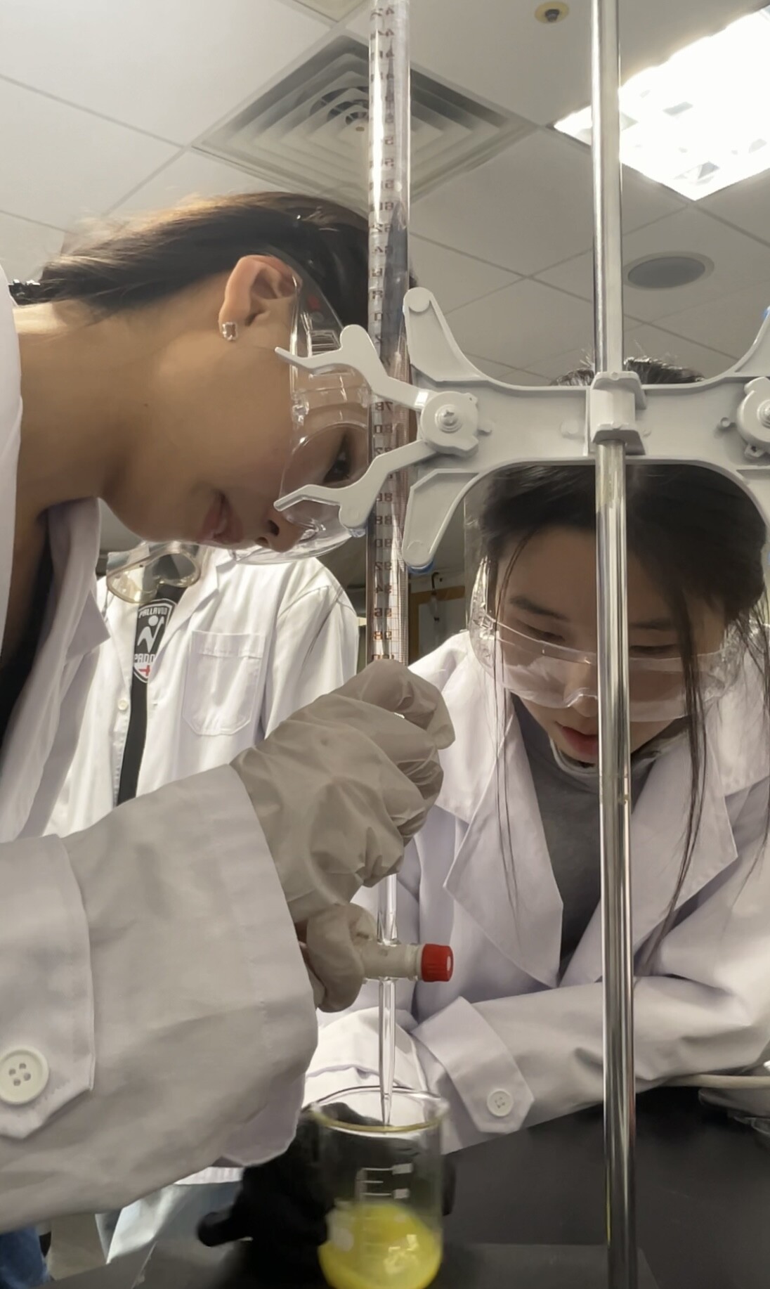 Grace and a lab partner conducting a titration experiment