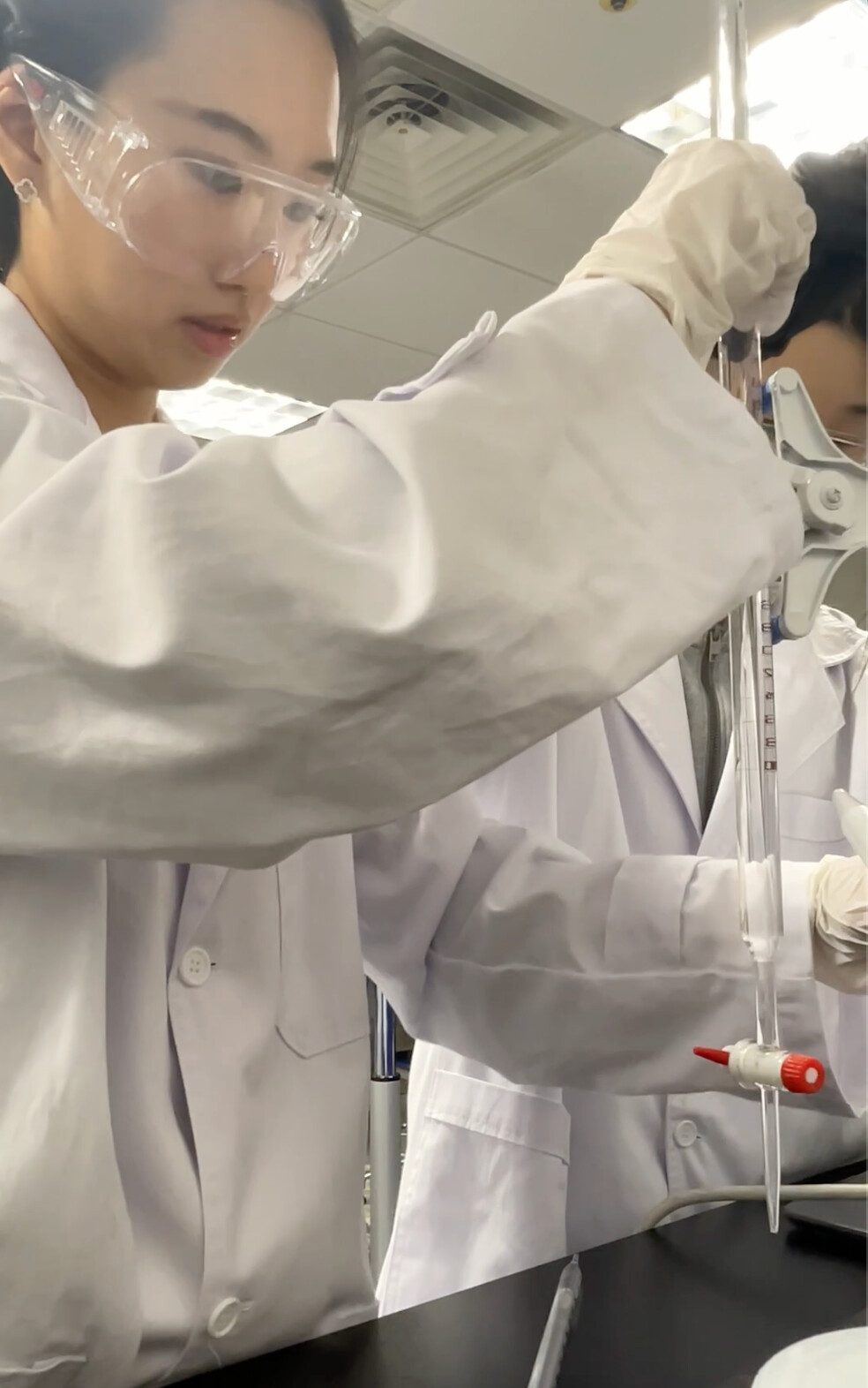 Grace carefully adjusting titration equipment