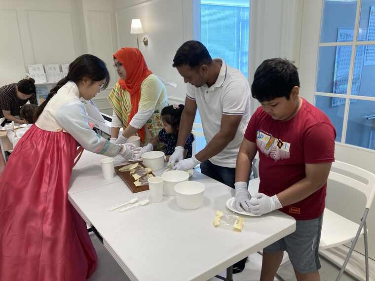Families from different cultural backgrounds making songpyeon together