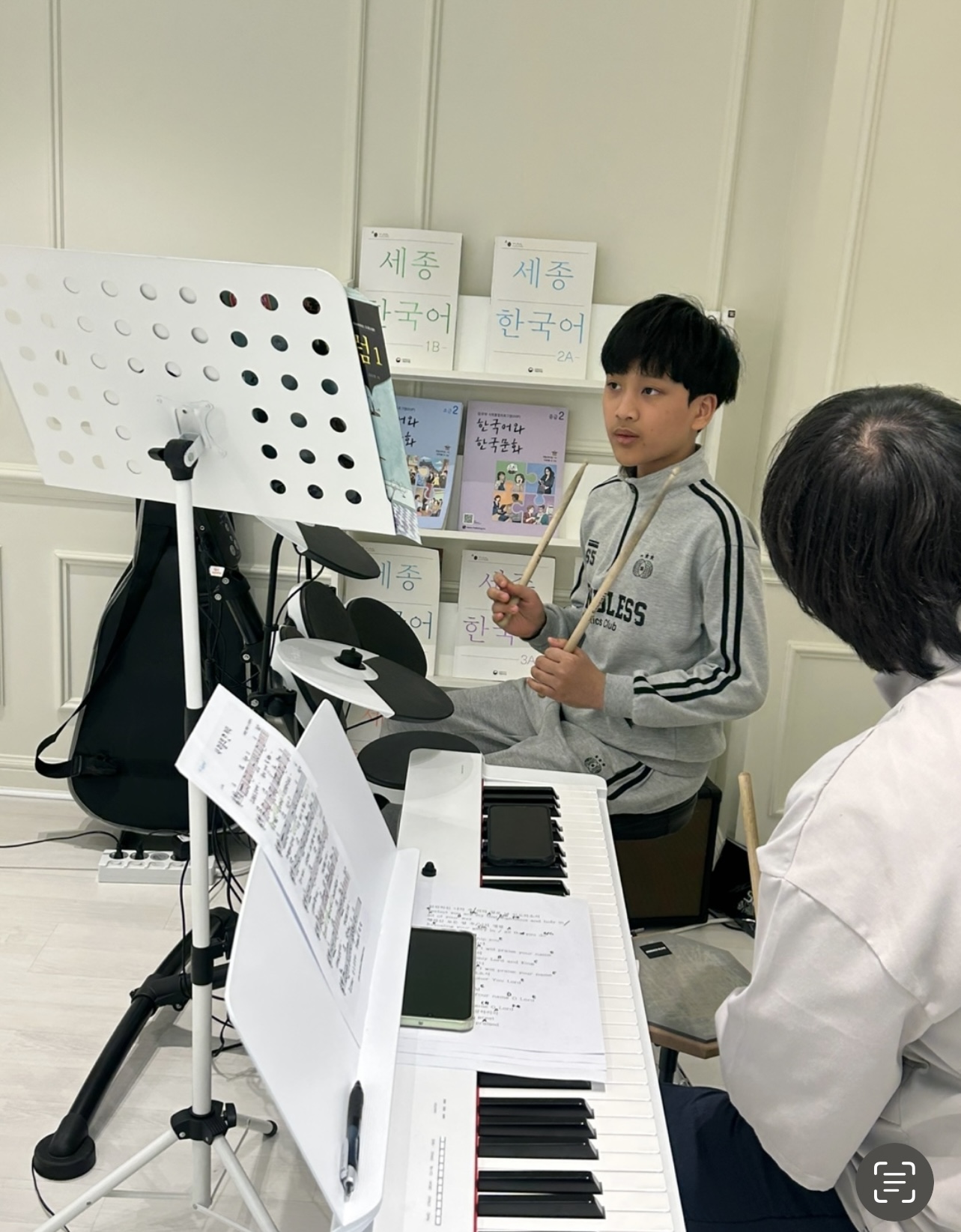 A student receiving a drum lesson