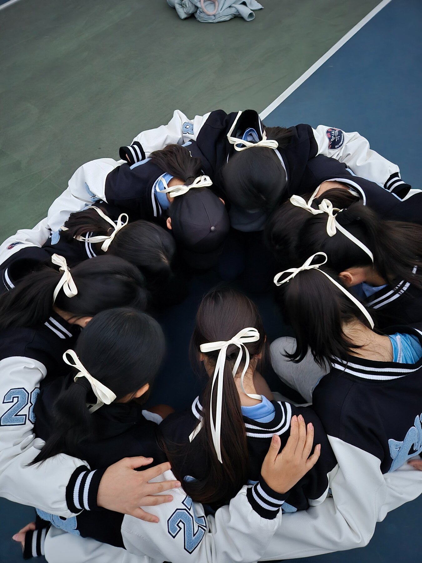 Grace and her tennis teammates gathering in a team huddle
