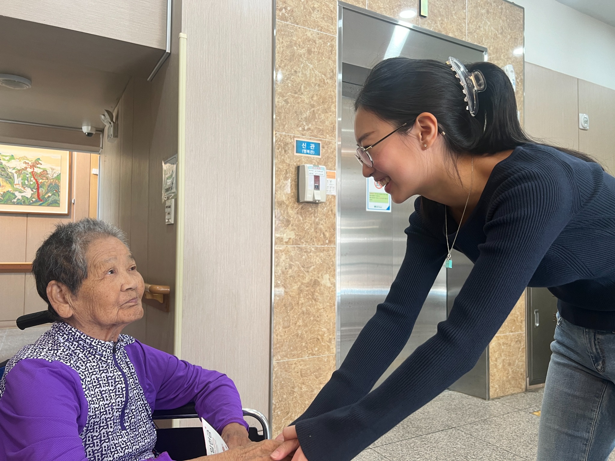 Grace sharing a caring moment with a nursing home resident
