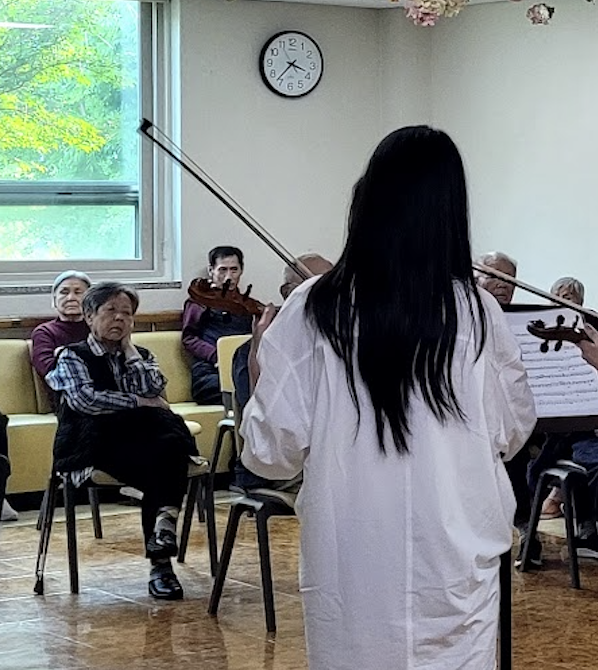 Students performing music for nursing home residents