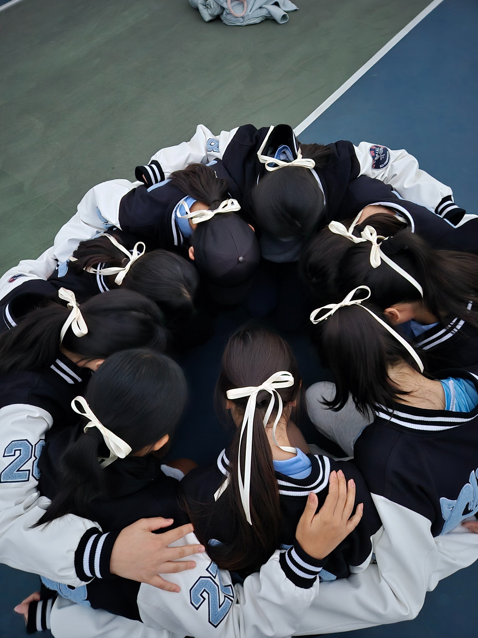 Varsity tennis team huddling together